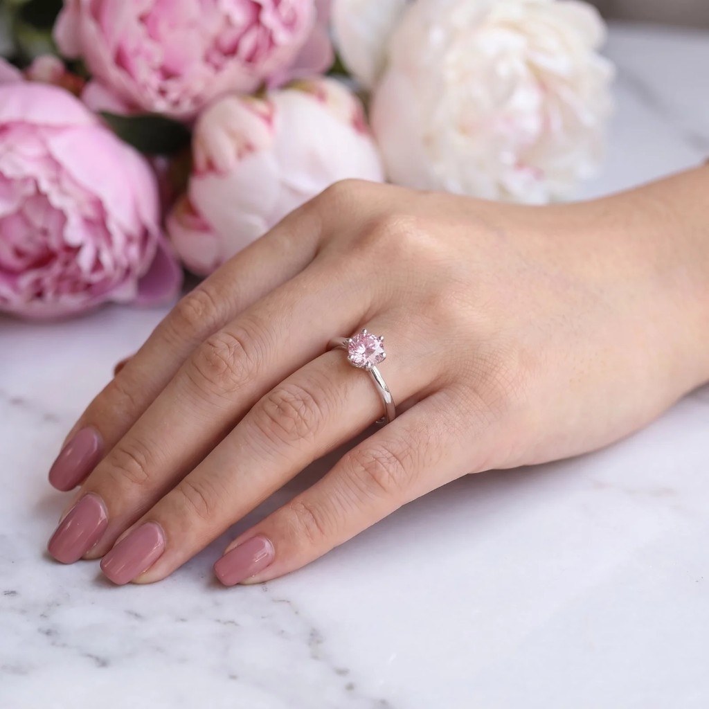 Sakura solitaire ring on a manicured hand